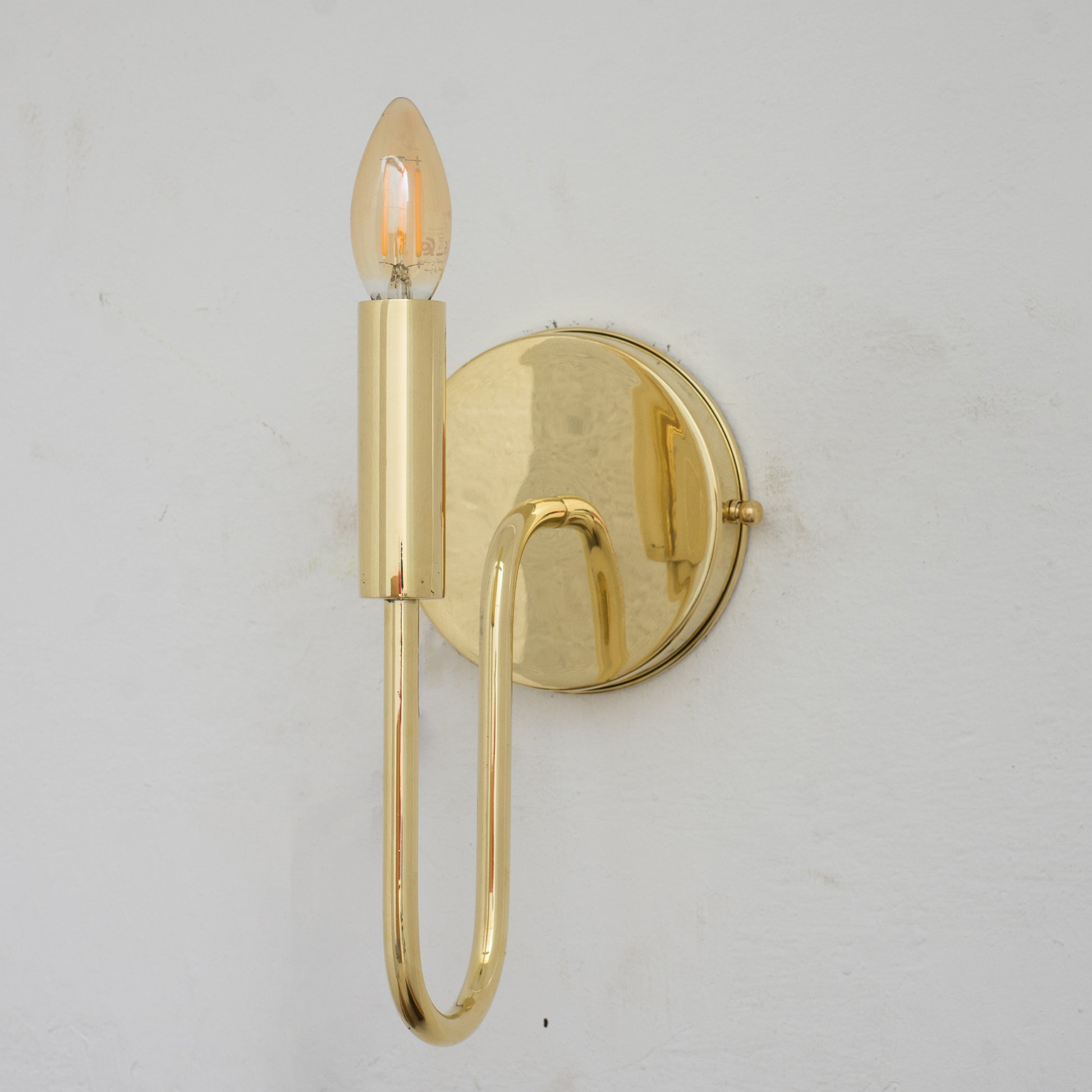 Experience authentic craftsmanship With our Unlacquered Brass Arch Sconce Light that will develops natural patina with time.