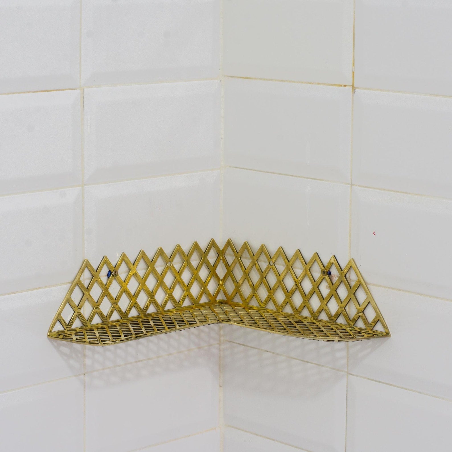 Experience authentic craftsmanship With Insideast Solid Brass Double Grid Corner Shelf that will develop natural patina with time.