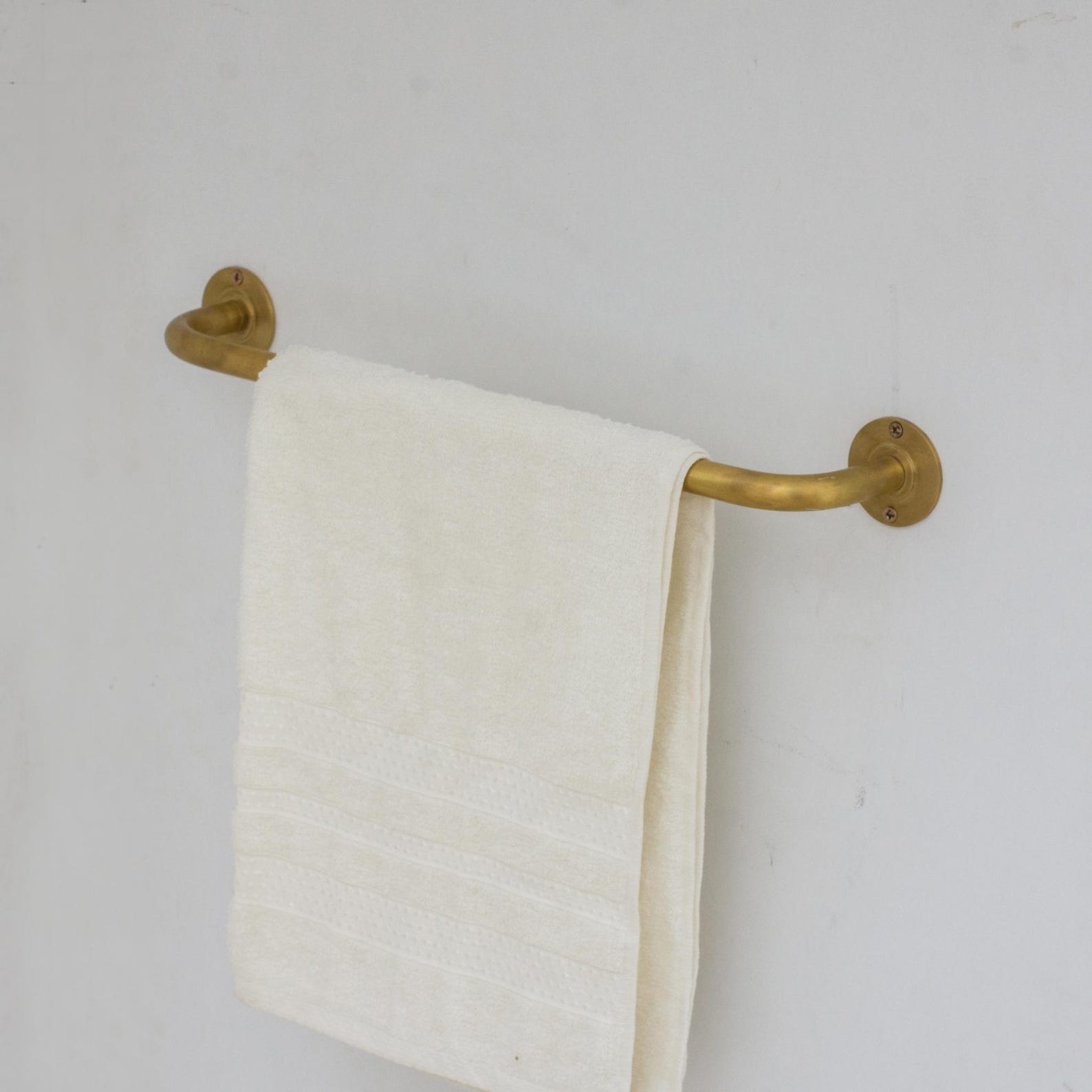 Experience authentic craftsmanship With Insideast Unlacquered Brass Towel Bar Holder that develops warm patina over time.