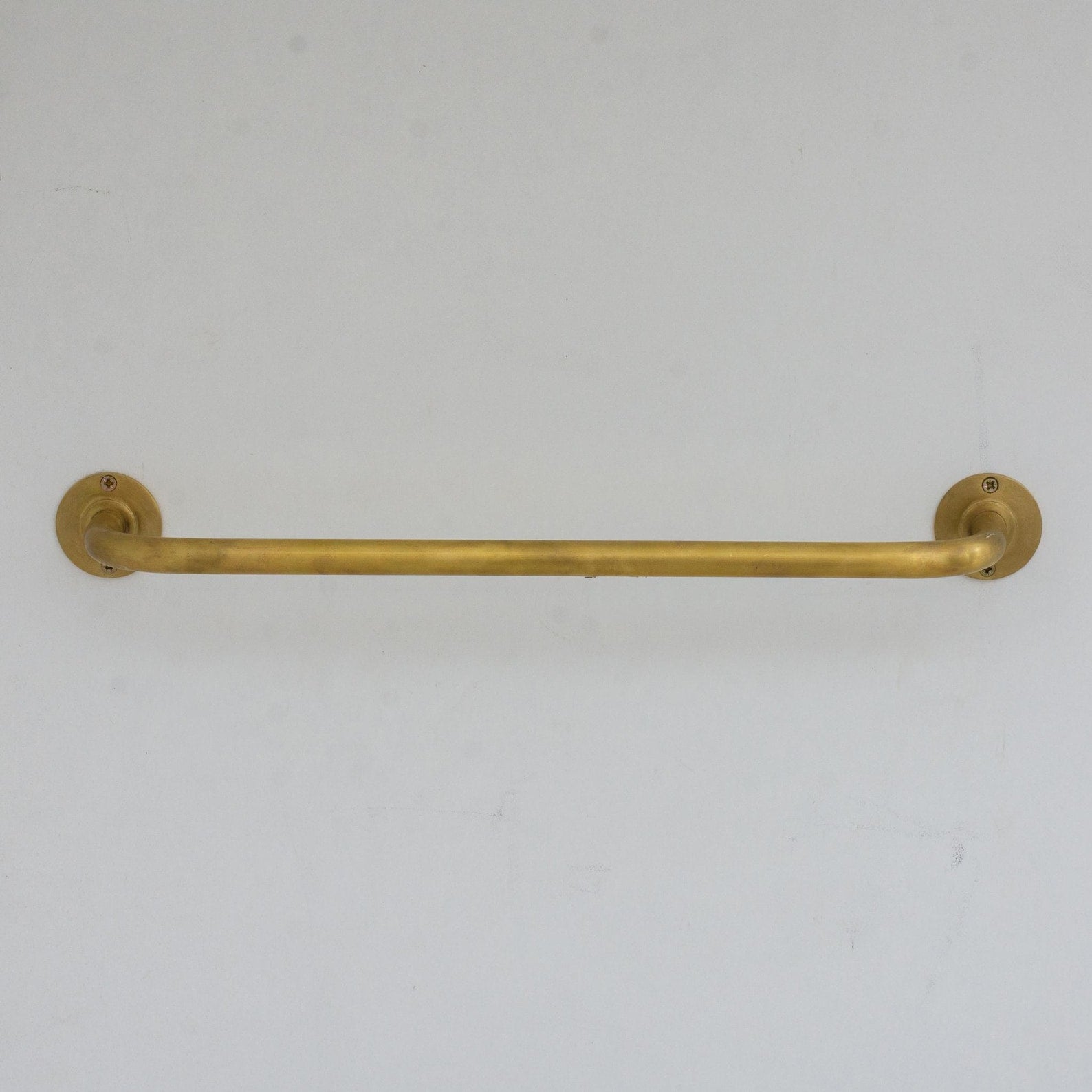 Experience authentic craftsmanship With Insideast Unlacquered Brass Towel Bar Holder that develops warm patina over time.