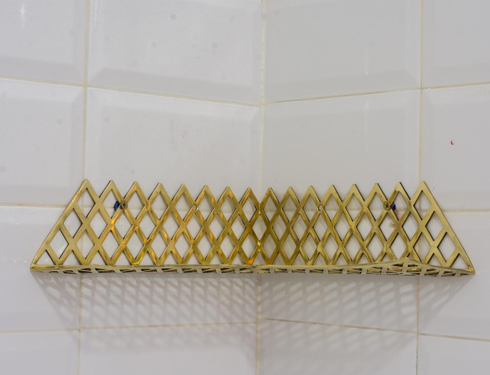 Experience authentic craftsmanship With Insideast Solid Brass Double Grid Corner Shelf that will develop natural patina with time.