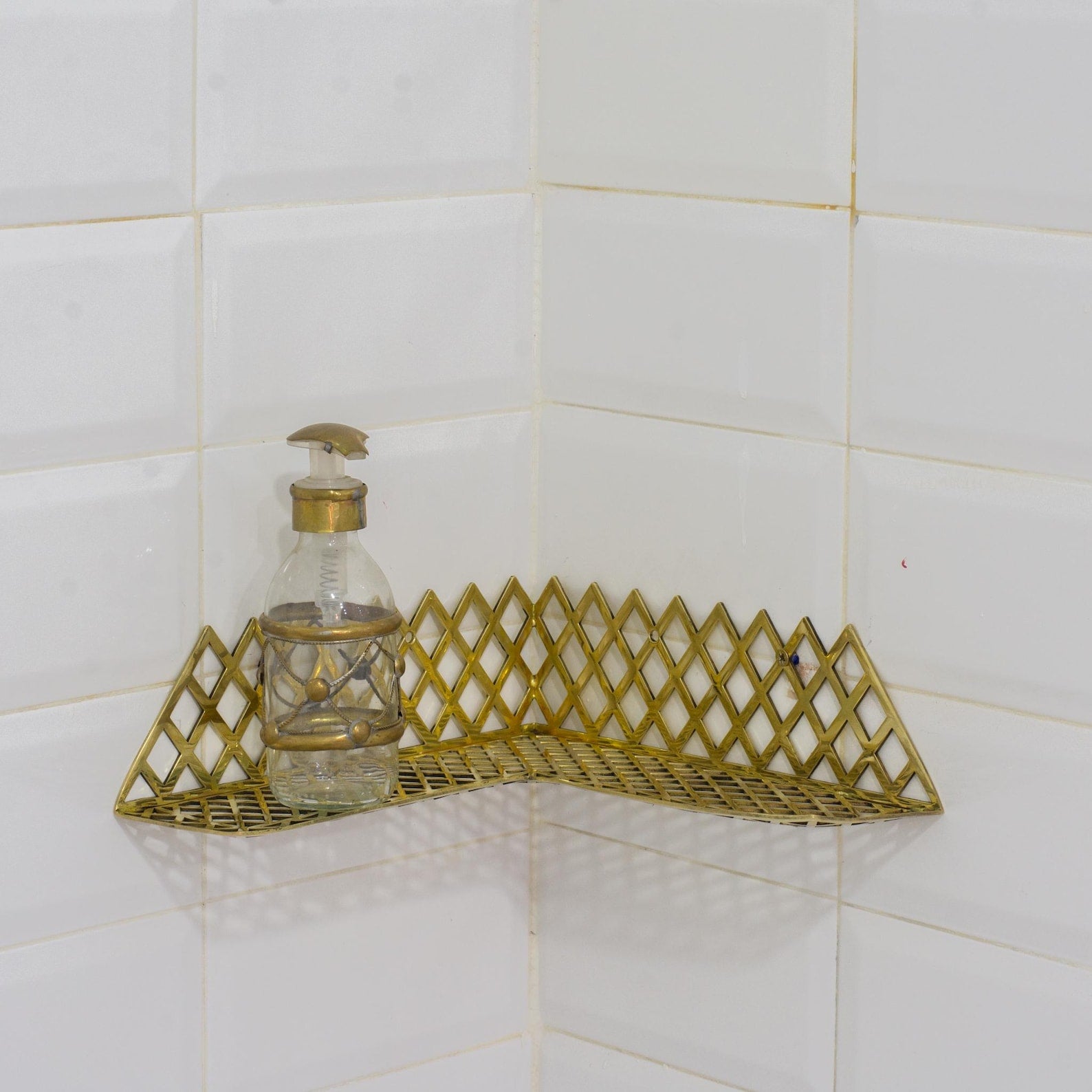 Experience authentic craftsmanship With Insideast Solid Brass Double Grid Corner Shelf that will develop natural patina with time.