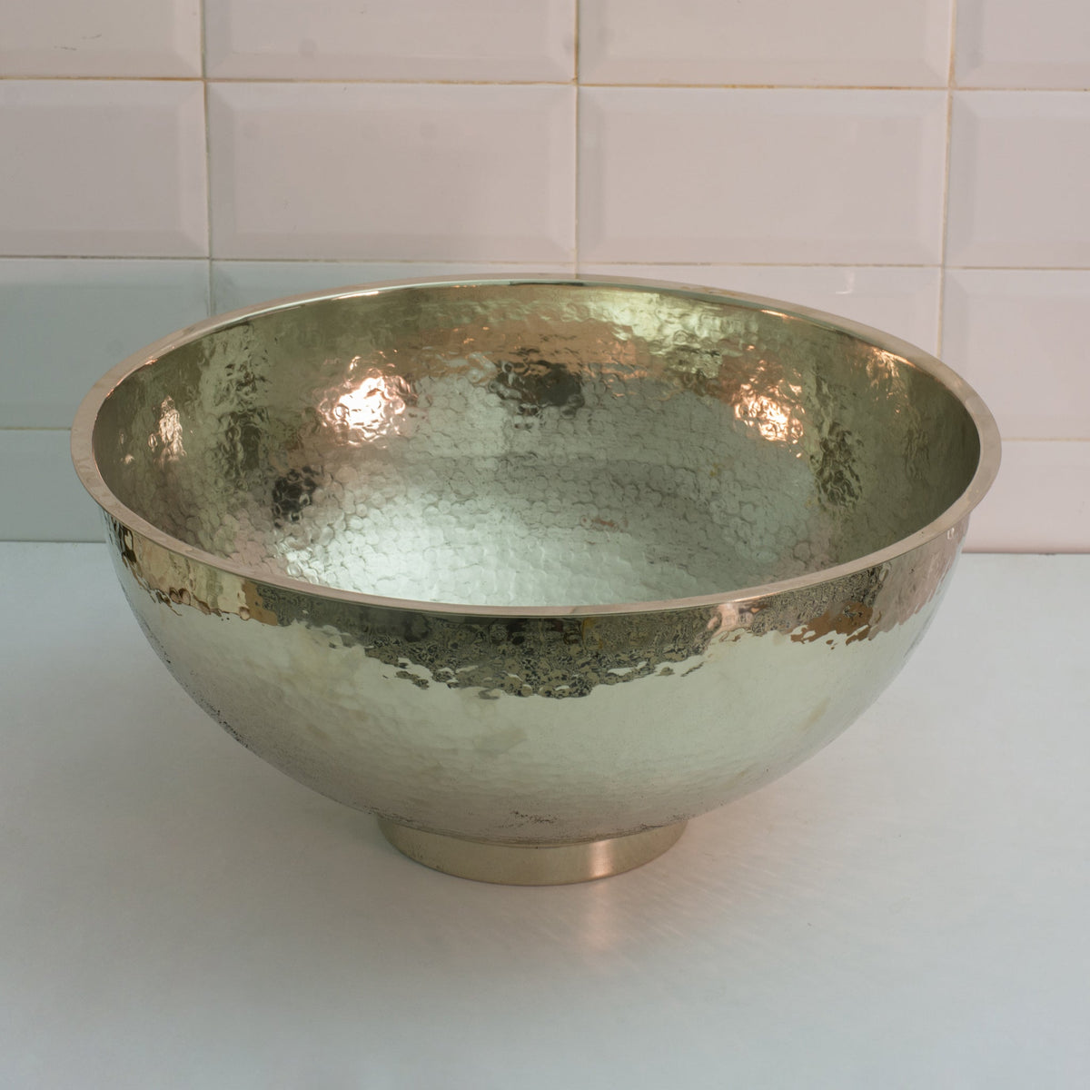 Hammered German silver bowl vessel sink on a bathroom vanity