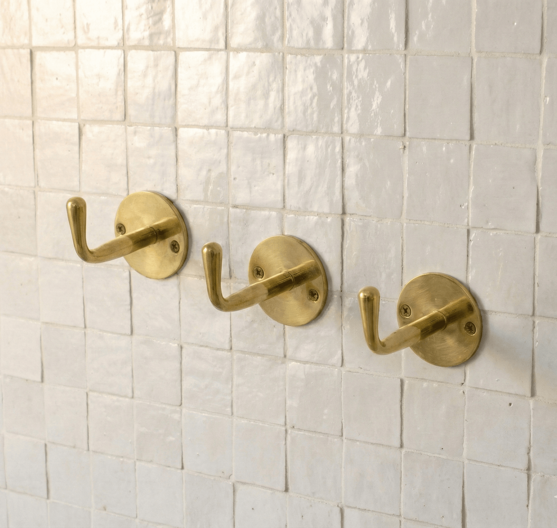 Single unlacquered brass wall hook, the same style referenced in Shireen's review
