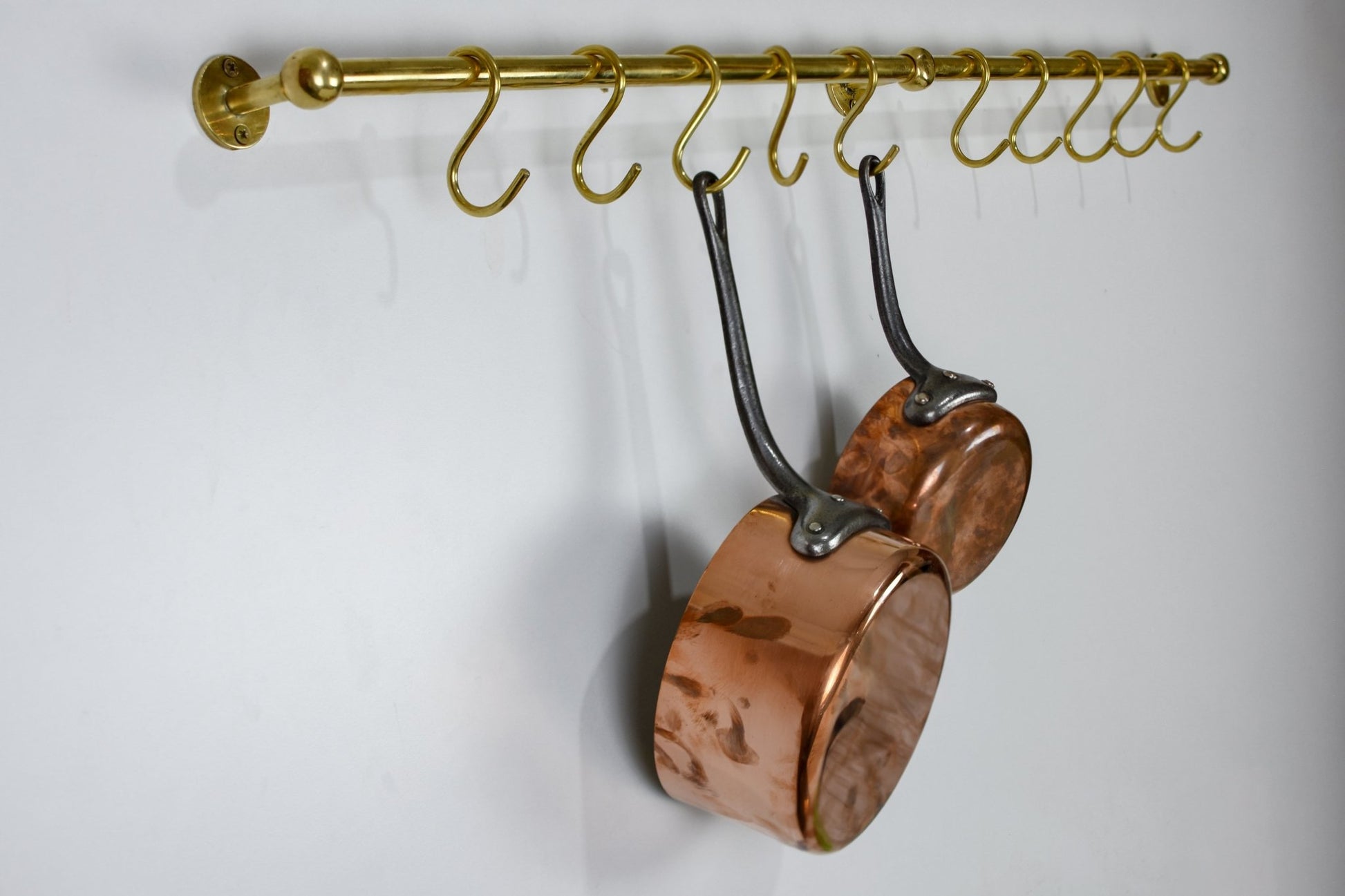 Unlacquered brass kitchen pot rail with S-hooks, wall-mounted pan rack organizer