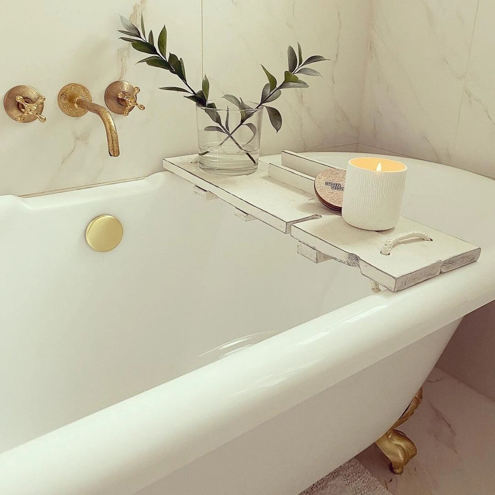 Unlacquered brass vintage wall-mounted faucet with cross handles used as a tub filler
