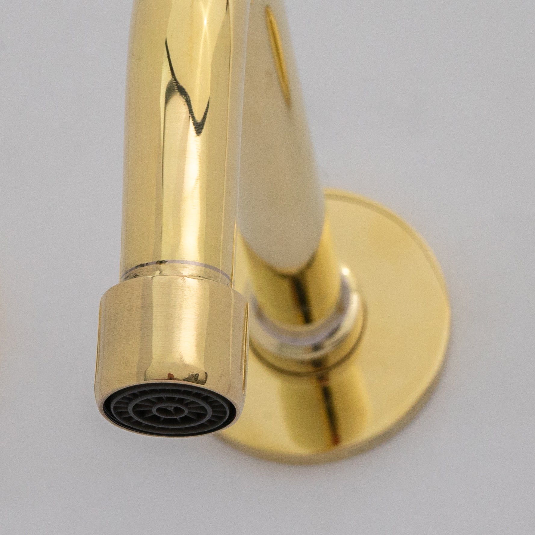 Wall mounted brass faucet over vessel sink in bathroom